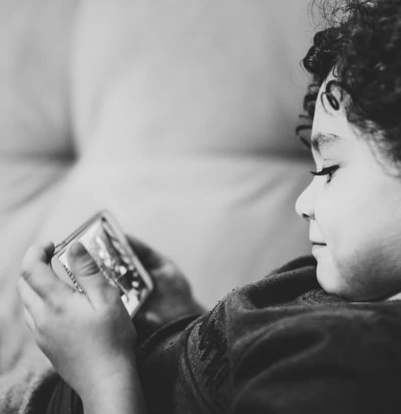 black and white photo of child playing phone games